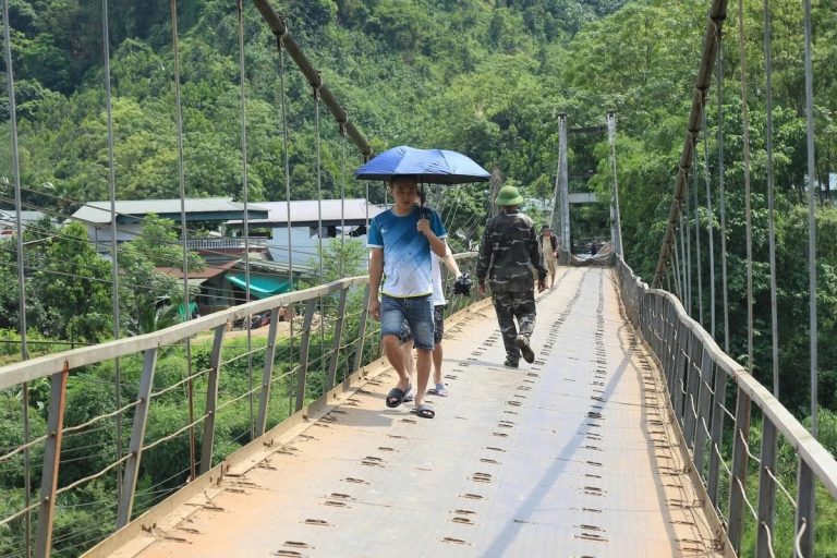 Ứng dụng dây cáp thép trong cầu đường – Cầu treo dân sinh Cầu treo dân sinh có hệ thống dây cáp treo, lan can hai bên và người đi bộ, minh họa ứng dụng cáp thép trong cầu đường
